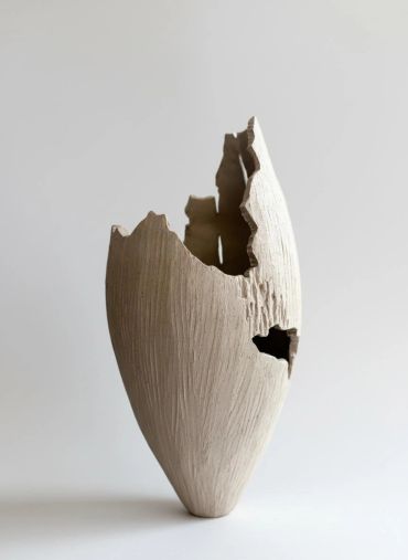 Broken white ceramic vase with textured surface.