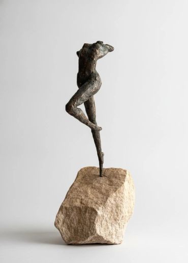 Abstract headless figure balancing on a rock.