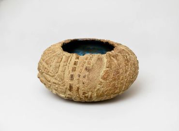 Textured round ceramic bowl with blue interior.