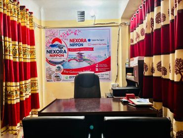 A cozy office space with red and gold curtains and a promotional banner on the wall.