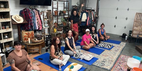 Group of women on yoga mats in a cozy indoor setting.
