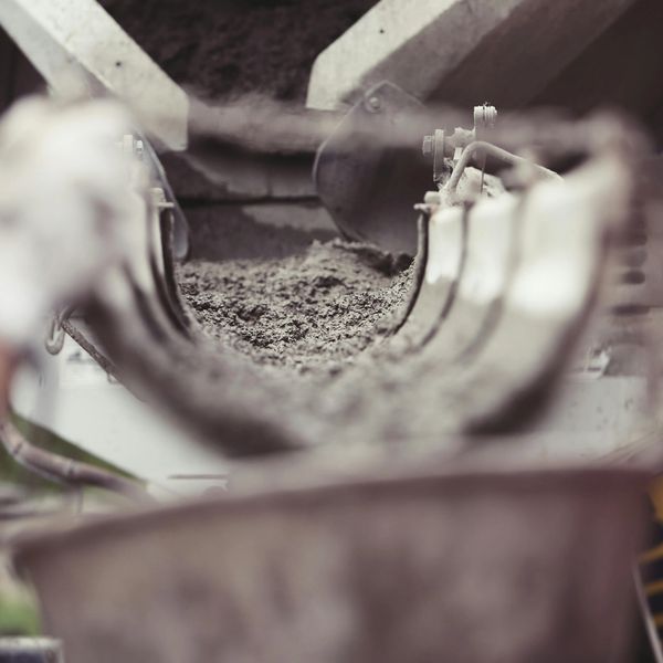 Wet concrete flowing through a chute.