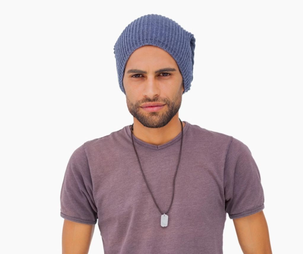 young bi-racial male standing up wearing a  mid purple t-shirt and blue beanie