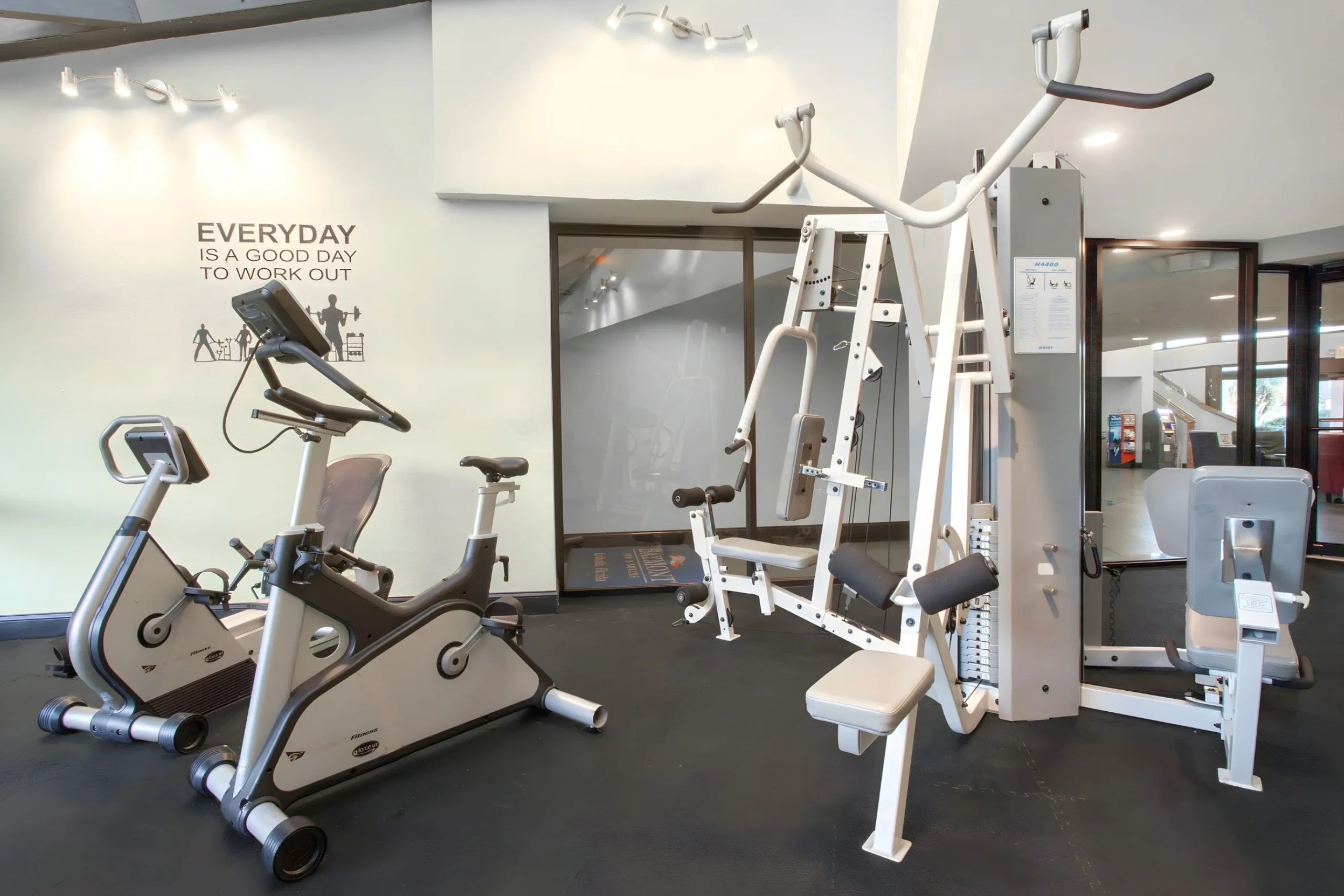A gym with exercise equipment including stationary bikes and a weight machine.