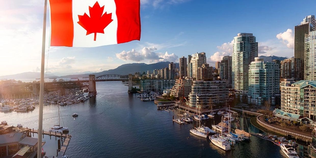 Canadian flag over a city marina at sunset.