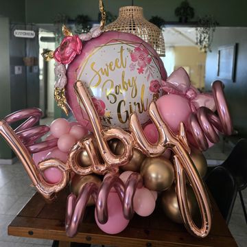 Pink and gold baby girl balloon decoration.