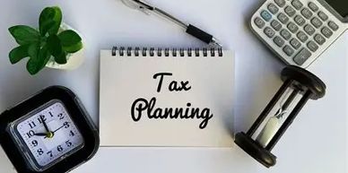 Notebook with 'Tax Planning' surrounded by a clock, calculator, pen, and hourglass.