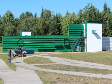Green and white industrial gas valve station outdoors.