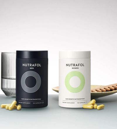 Nutrafol supplement canisters for both men and women with a glass of water for hair health.