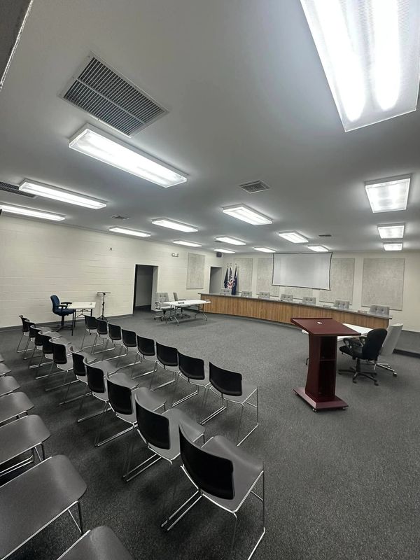 Empty conference room with rows of chairs and a podium.