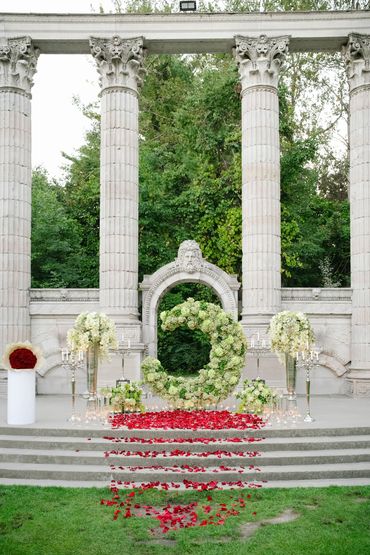 Elegant outdoor Moon Proposal setup with green florals and rose petals.