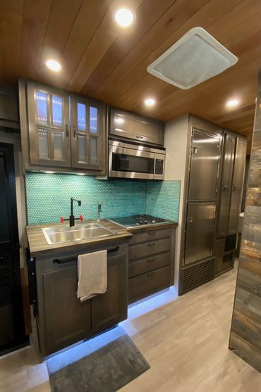 Kitchen featuring rusted penny copper rounds backsplash.