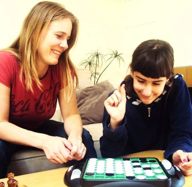 Our sitter with a client's child playing board games.