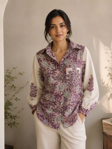 Woman wearing a floral patterned shirt with cream sleeves.