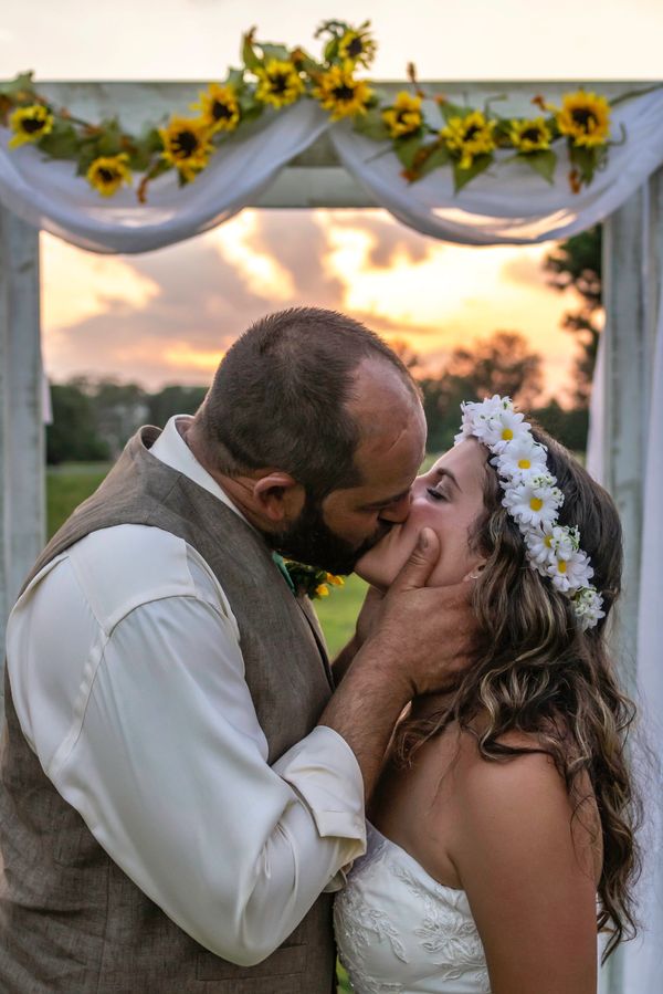 Bride and groom kissing at the altar during sunset