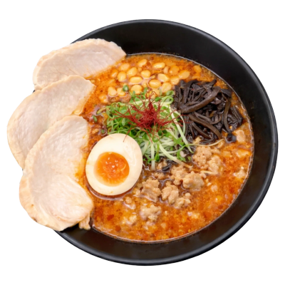Bowl of spicy ramen with egg, chicken slices, and corn.