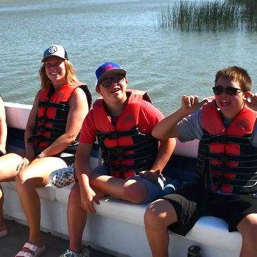 Staff and two campers on the pontoon.