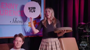 Woman holds a 'BIRD FLU' sign during a show scene.