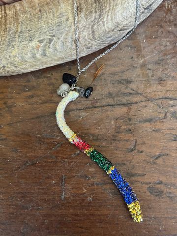 Colorful beaded necklace pendant on a wooden surface.