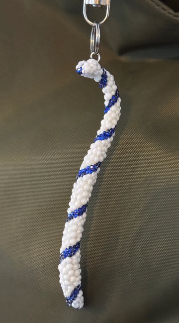Beaded keychain with white and blue spiral design.