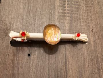 Decorative hairpin with a gem and floral details.