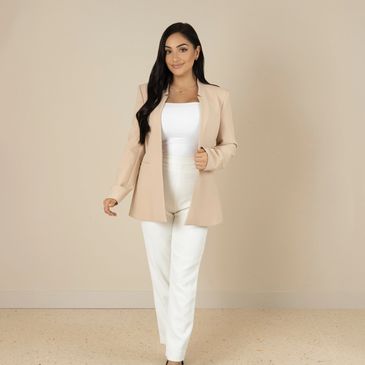 Woman in beige blazer and white outfit.