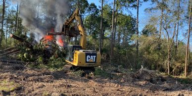 Dozer clearing land, burning trees and brush for site prep. 