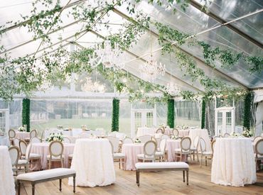 Clear wedding tent with white and pink clothed tables