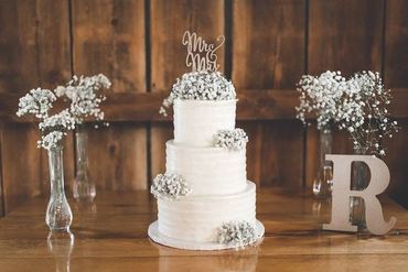 White 3 tier floral wedding cake sitting on a table