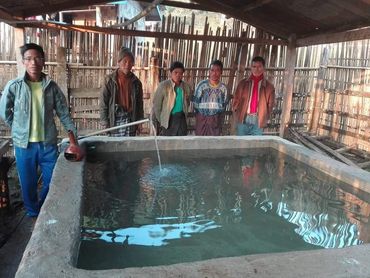  people filling a large container with water;