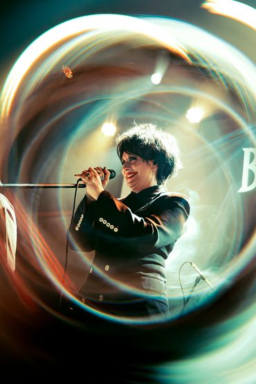 Close-up of a vocalist singing during a PNW concert.
