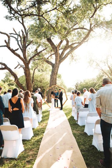 Outdoor wedding ceremony under large tree.