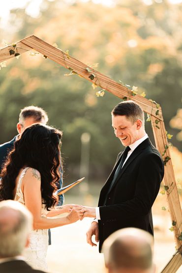 bride places ring on grooms finger during documentary style Washington wedding