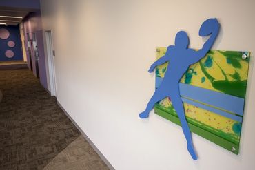 Blue silhouette of a football player on a hallway wall.