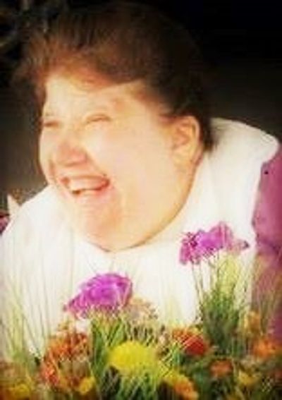 Beautiful child with special needs surrounded by flowers. Support Group Eagle Boise Meridian Idaho