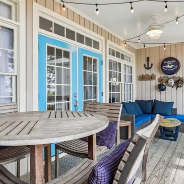 Cozy screened porch with rustic wooden furniture and blue accents.