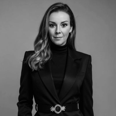 Confident woman in a stylish black blazer with hands in pockets.