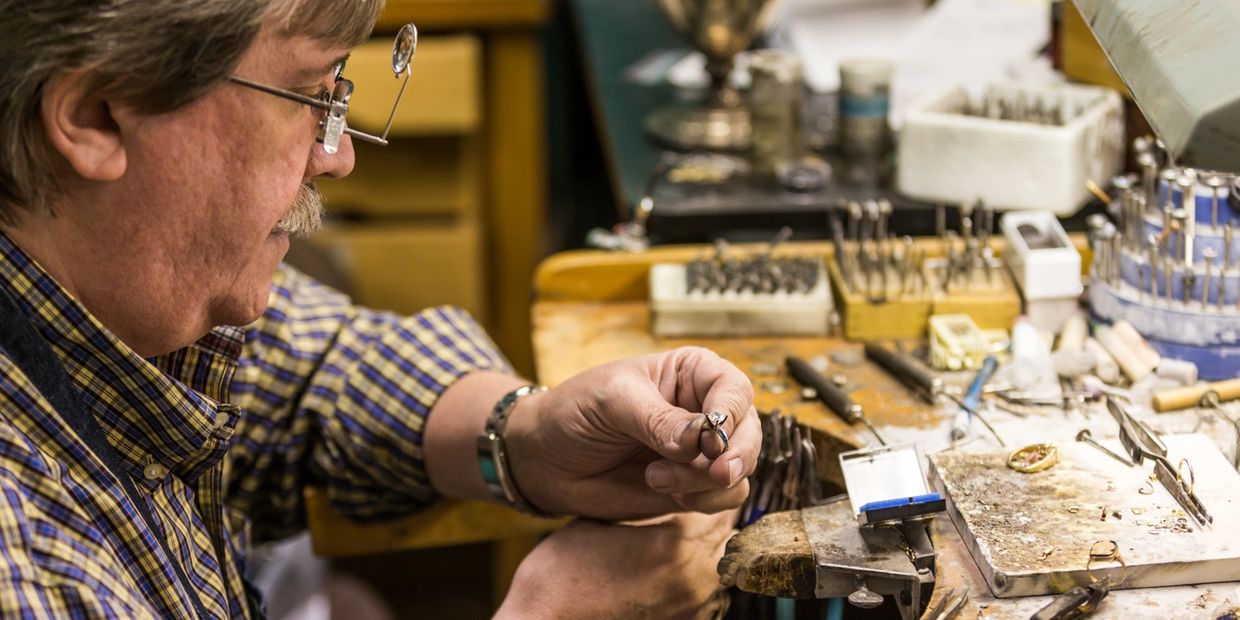 A man working on a jewelry in a shop