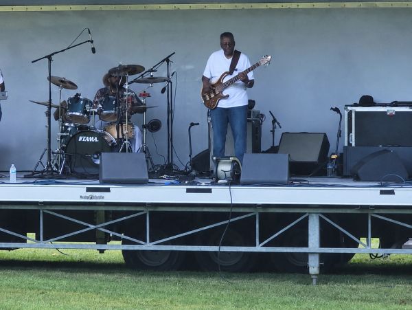 Two musicians performing on an outdoor stage.