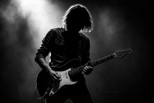 Silhouette of a guitarist playing electric guitar.