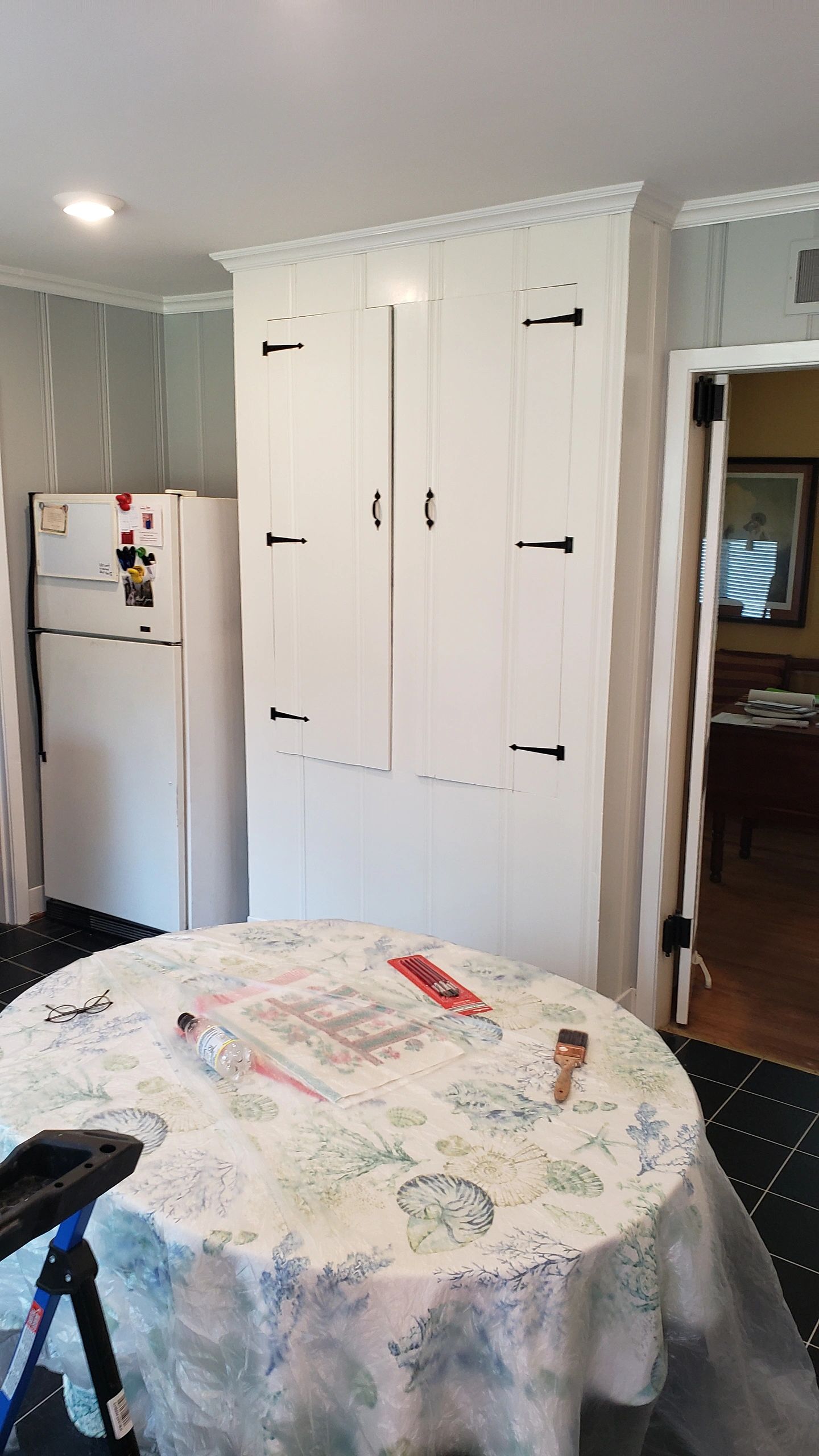 Kitchen scene with vintage refrigerator and white cabinet.