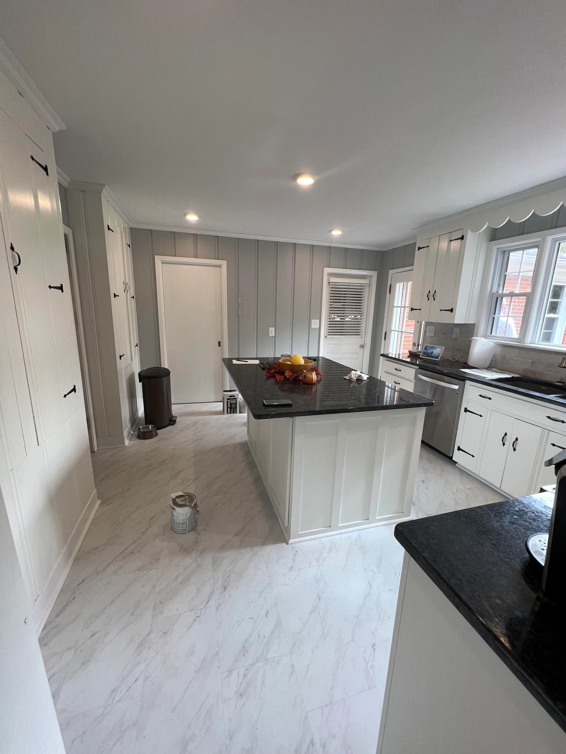 Modern white kitchen with black countertops and island.