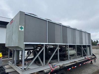 Large industrial HVAC unit on a trailer under a cloudy sky.