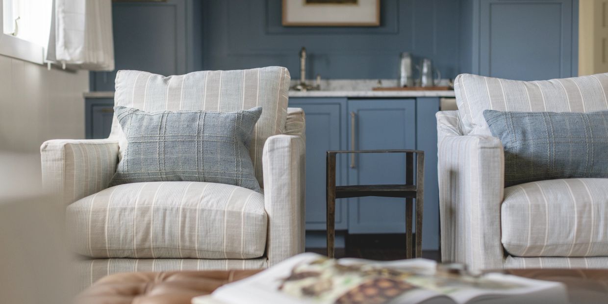 Two striped armchairs with blue cushions in a cozy living room setting.