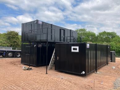 Black modular container units stacked outdoors.
