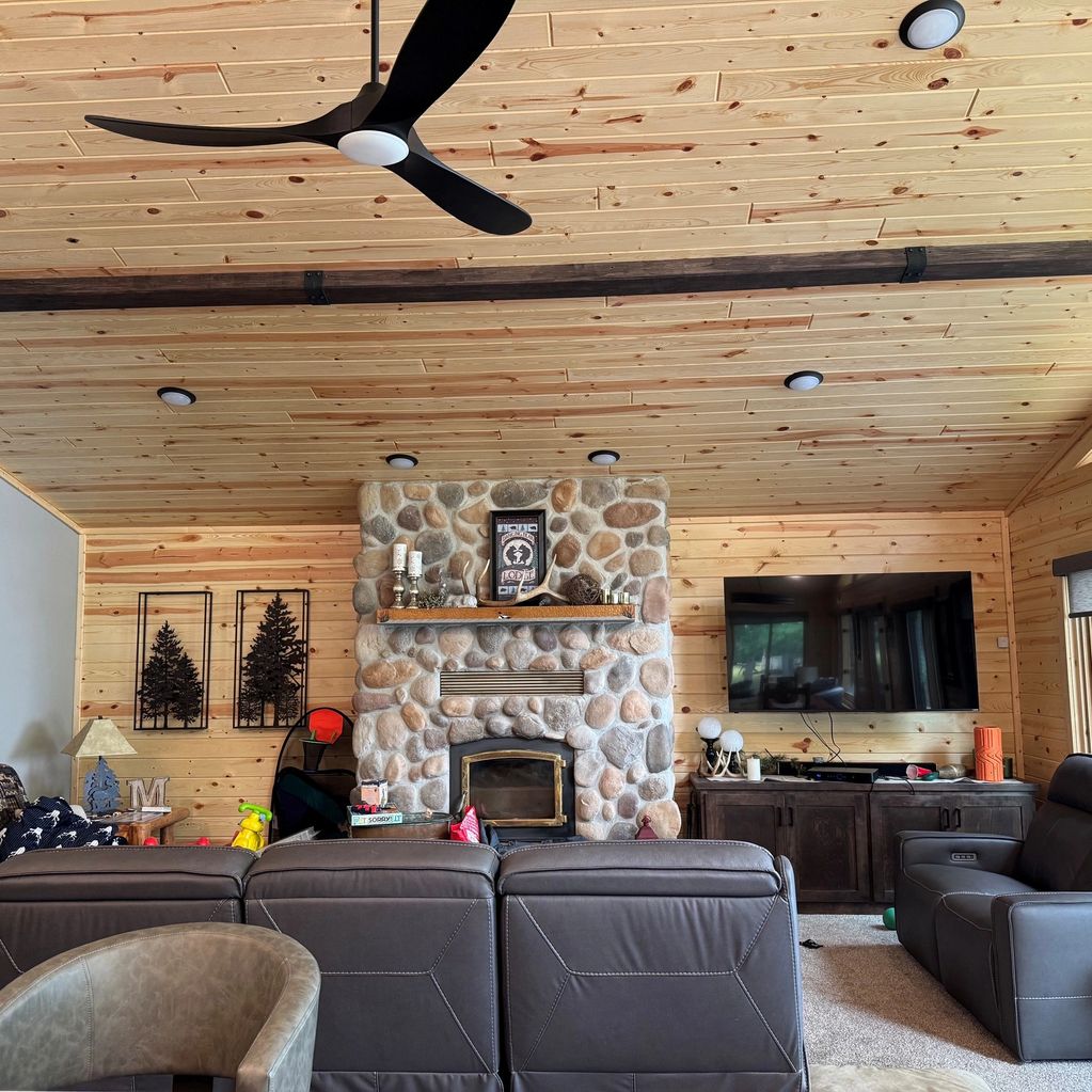 Cozy living room with stone fireplace and leather seating.