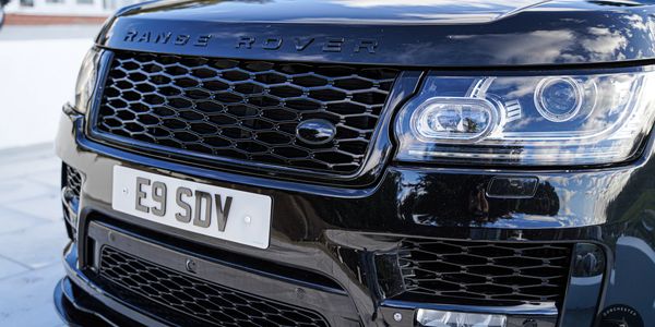 Close-up of Range Rover Vogue for hire iconic front grille, a mark of luxury.
