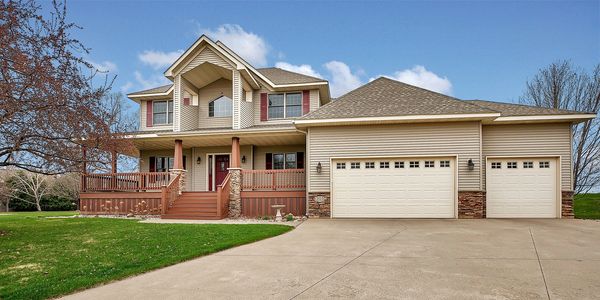 Spacious two-story house with a three-car garage and a welcoming front porch.