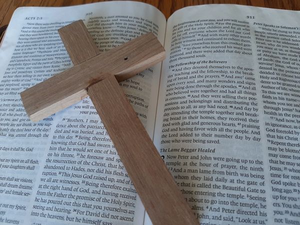 wooden cross on bible pages