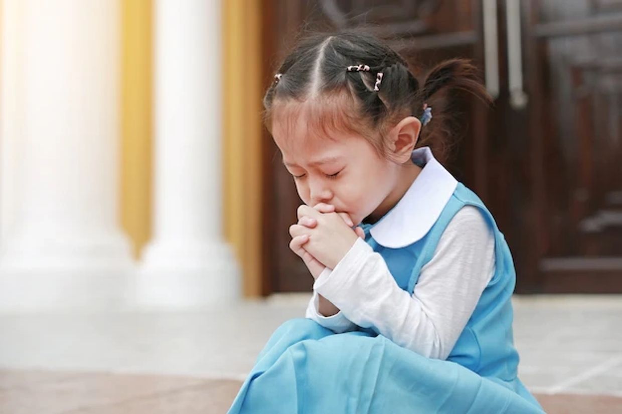 Asian girl, eyes & hands in prayer posture, church step, hair in berets, sky blue dress, white shirt